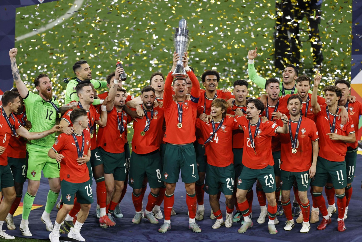 Portugal's forward #07 Cristiano Ronaldo (C) raises the trophy after winning the UEFA Nations League final football match between Portugal and Spain in Munich, southern Germany on June 8, 2025. (Photo by Alexandra BEIER / AFP)
