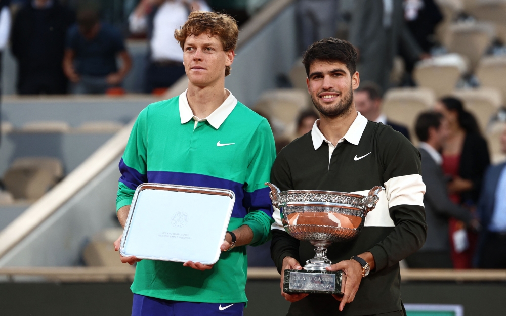 Winner Spain's Carlos Alcaraz (R) poses with the trophy next to Italy's Jannik Sinner at the end of their men's singles final match at the Roland-Garros Complex in Paris on June 8, 2025. (Photo by Thibaud Moritz / AFP)