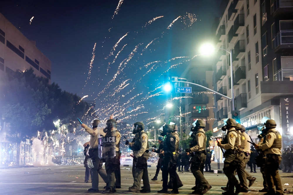 A firework explodes near police patrolling as protests continue in Los Angeles following three days of clashes with police after a series of immigration raids on June 09, 2025 in Los Angeles, California. Mario Tama/Getty Images/AFP 