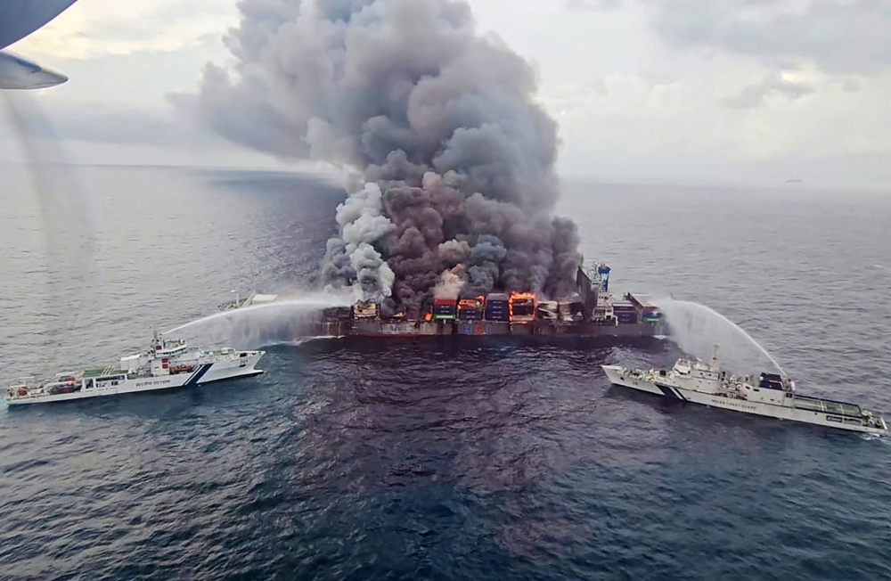 Handout photograph released on June 10, 2025 by the Indian Coast Guard (ICG) shows smoke billowing from Singapore-flagged container ship MV Wan Hai 503 in India's Kerala state. (Photo by Indian Coast Guard (ICG) / AFP) 