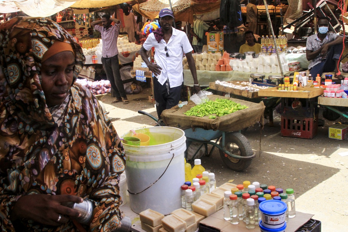 Sudanese people sell goods at an open market in the East Nile district of Khartoum on May 19, 2025. (Photo by Ebrahim Hamid / AFP)