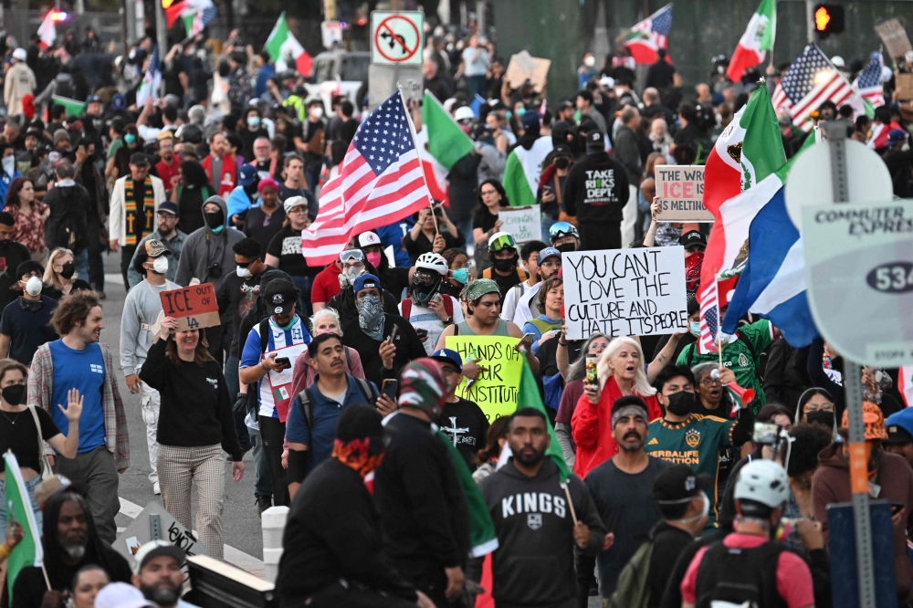 Demonstrators march in front of the Federal Building before curfew goes in effect in Los Angeles on June 10, 2025. (Photo by Robyn Beck / AFP)