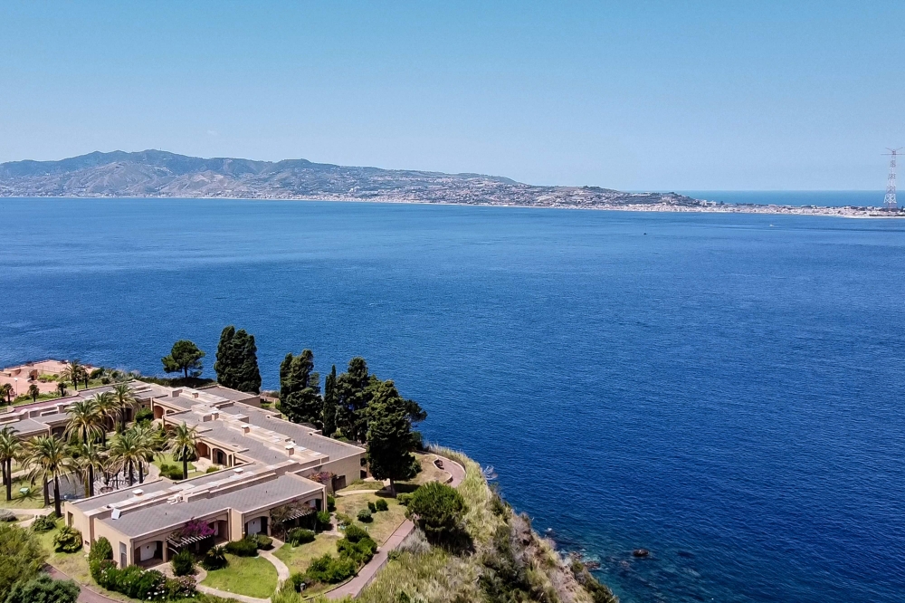 (Files) A general aerial view shows the Sicilian coast towards Cape Torre Faro, over the Strait of Messina, taken from the outskirts of the town of Scilla, in Calabria region in southern Italy, on July 7, 2020. (Photo by Andreas Solaro / AFP)