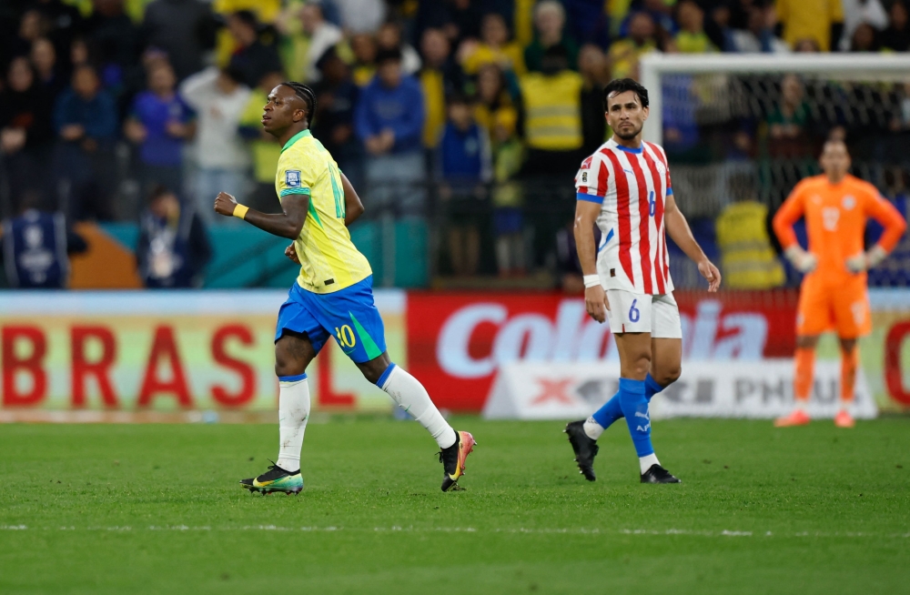 Brazil's forward #10 Vinicius Jr (L) celebrates after scoring his team's first goal past Paraguay's defender #06 Junior Alonso during the 2026 FIFA World Cup South American qualifiers football match between Brazil and Paraguay at the Neo Quimica Arena in Sao Paulo, Brazil, on June 10, 2025. (Photo by Miguel Schincariol / AFP)