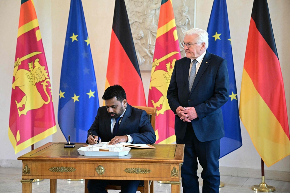 Sri Lankan President Anura Kumara Dissanayake signs the visitor's book next to German President Frank-Walter Steinmeier during an official welcome ceremony at the presidential Bellevue Palace in Berlin, on June 11, 2025. (Photo by Tobias Schwarz / AFP)
