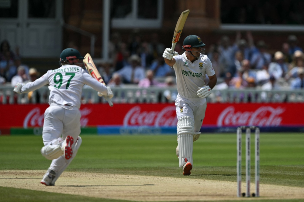 South Africa's wicket keeper Kyle Verreynne (L) and David Bedingham (R) celebrate victory, at Lord's cricket ground, in London, on June 14, 2025. (Photo by Glyn Kirk / AFP) 