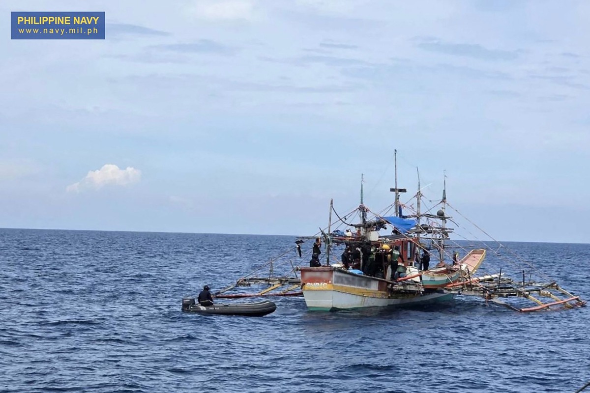 This handout photo taken on June 20, 2025 and received from the Philippine Navy shows navy and law enforcement personnel searching a fishing boat after it was intercepted carrying 1.5 tonnes of illegal drugs off the coast of the main island Luzon. Photo by Handout / Philippine Navy / AFP