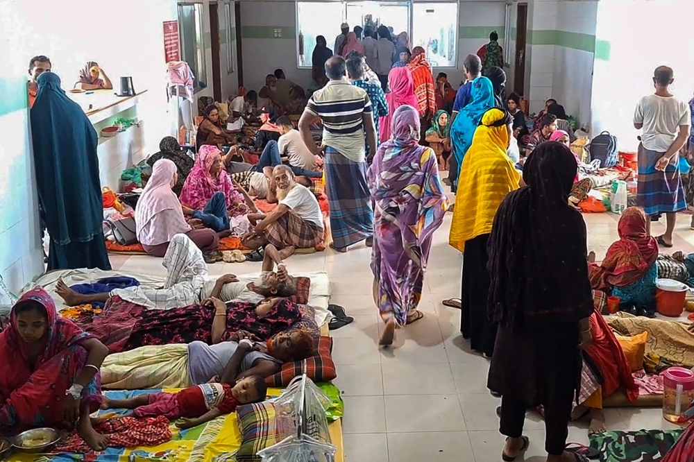 Dengue patients along with their family members are pictured at a hospital in Barguna in southern Bangladesh on June 22, 2025. (Photo by Arifir Rahman / AFP)