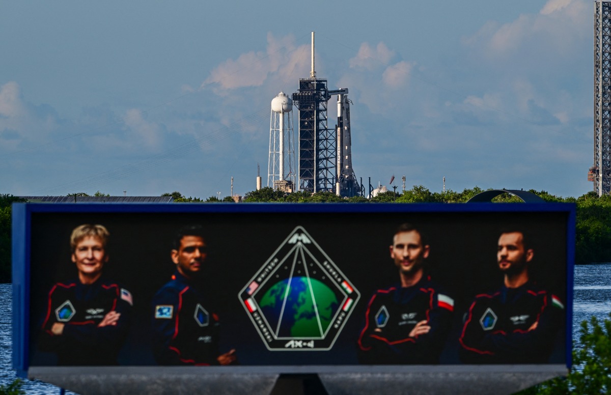 Pictures of the mission astronauts are seen as SpaceX Falcon 9 rocket and Dragon spacecraft sit on the pad of Launch Complex 39A at NASA's Kennedy Space Center ahead of the launch of Axiom Space Mission 4 on June 24, 2025, in Cape Canaveral, Florida. (Photo by Giorgio VIERA / AFP)