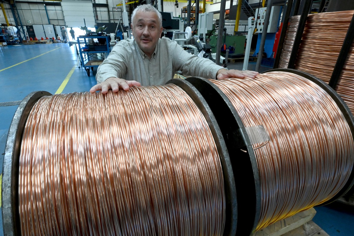 Photo used for representational purposes. Bruno Grandjean, President of Redex European engineering company, poses behind a reel of copper cable at Redex plant, in Ferrieres-en-Gatinais, central France, on June 18, 2025. Photo by JEAN-FRANCOIS MONIER / AFP.