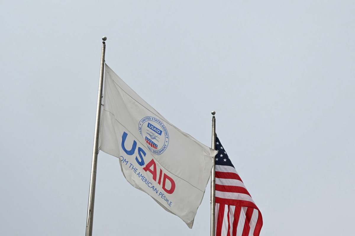 (FILES) A USAID and American flag fly before Congressional Democrats hold news conference outside of United States Agency for International Development (USAID) headquarters in Washington, DC, on February 3, 2025. (Photo by Mandel NGAN / AFP)