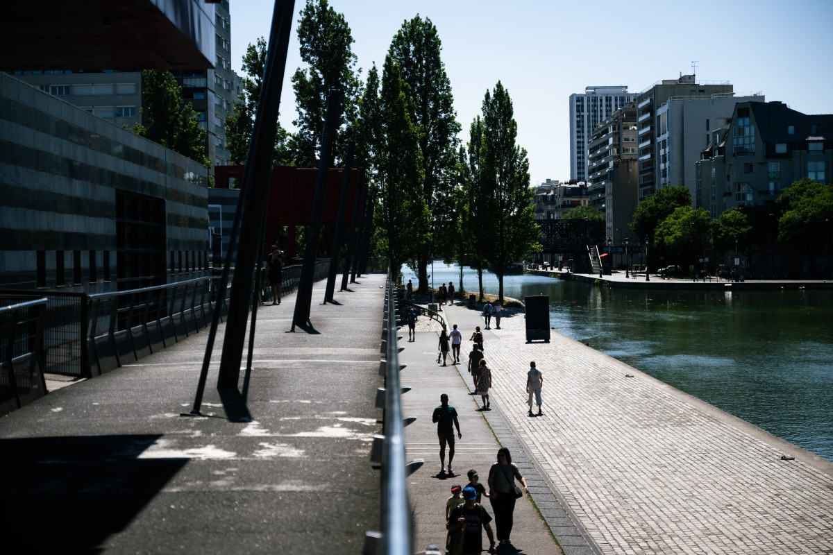 Pedestrians walk along the Canal de l'Ourcq at La Villette park as a heatwave hits Europe, in Paris on June 29, 2025. Photo by Julie SEBADELHA / AFP.
