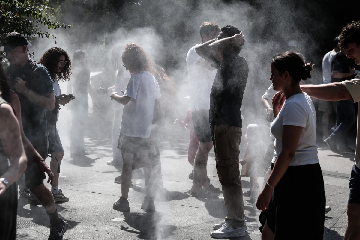 People cool off with misters in a park in the Halles district of Paris on July 1, 2025, as a heatwave hits France. (Photo by Thibaud MORITZ / AFP)
