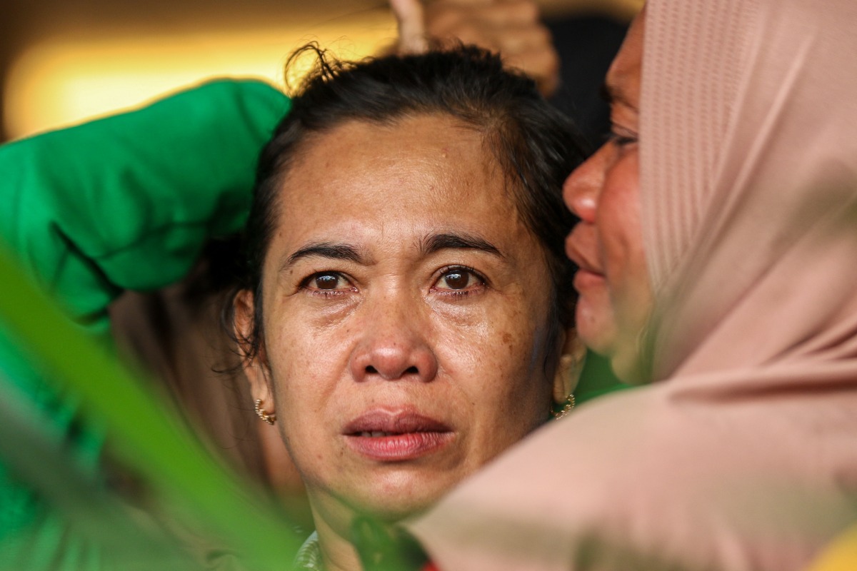 Family members and relatives wait for updates on the search operation of at least 61 people who were missing after a ferry sank off the popular Indonesian resort island of Bali, at Ketapang Port in Banyuwangi, East Java on July 3, 2025. (Photo by AFP)
