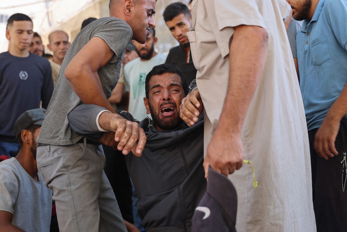 A Palestinian mourner breaks in tears during the funeral procession of people reportedly killed while waiting for aid delivery, outside al-Shifa hospital in Gaza City, on July 3, 2025. Photo by Omar AL-QATTAA / AFP