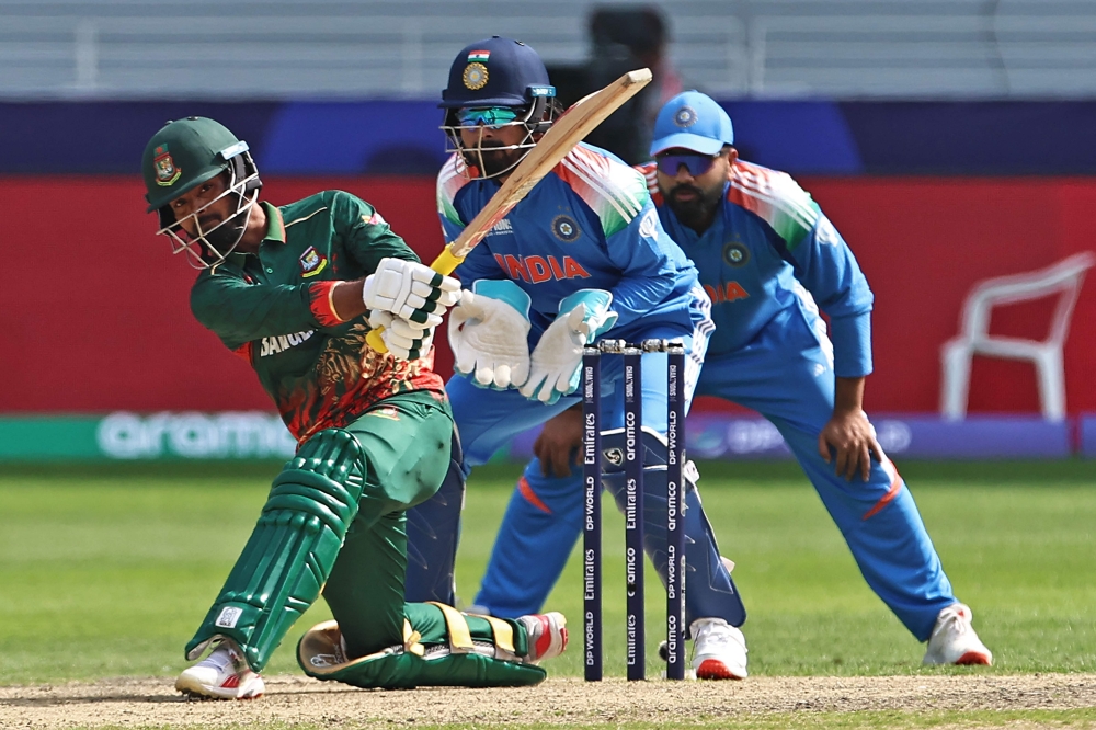 FILE PHOTO: Bangladesh's Towhid Hridoy (L) plays a shot as India's wicketkeeper KL Rahul (C) watches during the ICC Champions Trophy one-day international (ODI) cricket match between Bangladesh and India at the Dubai International Stadium in Dubai on February 20, 2025. (Photo by Fadel Senna / AFP)