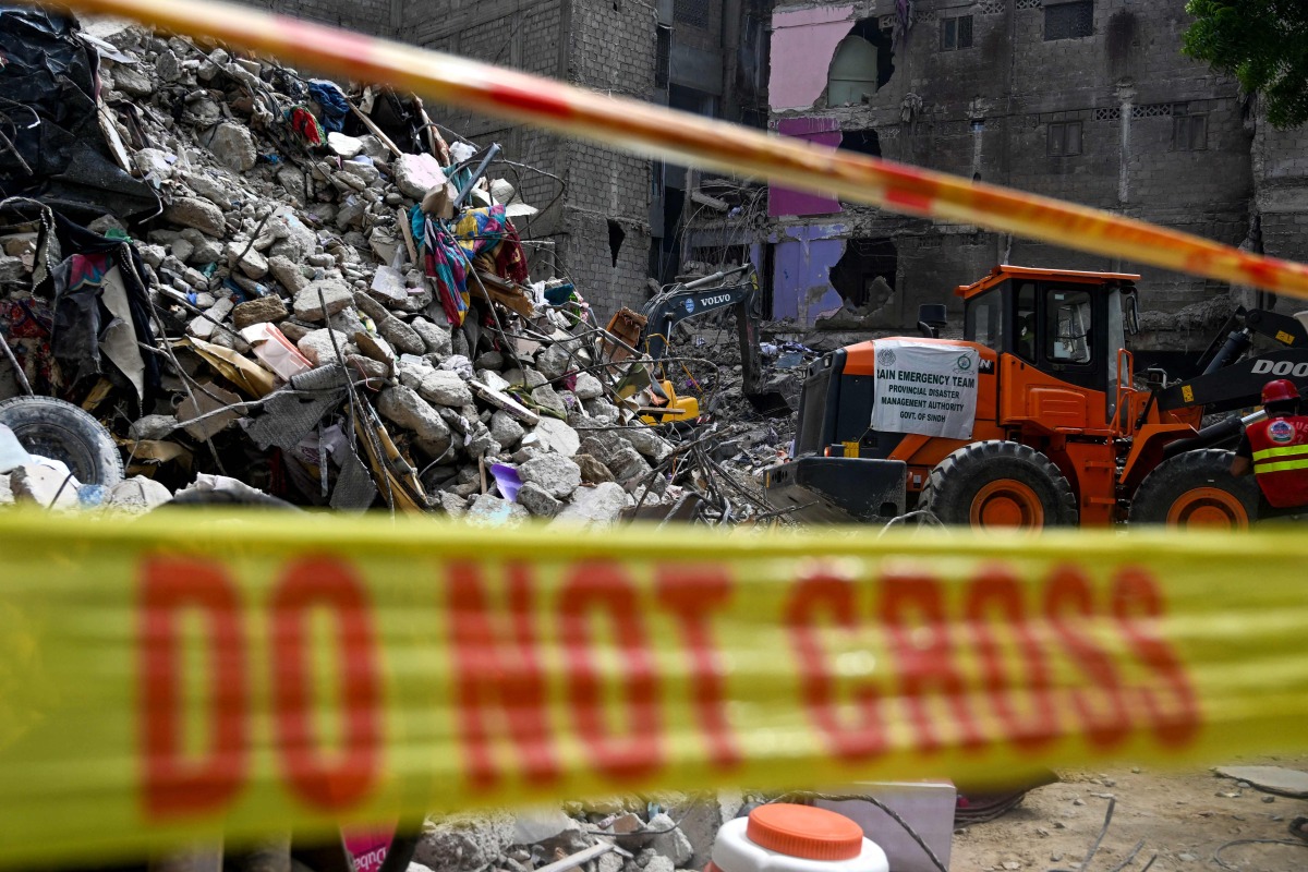 A rescue worker is pictured during a search operation amidst the debris of a collapsed building in Karachi on July 5, 2025. Photo by Rizwan TABASSUM / AFP