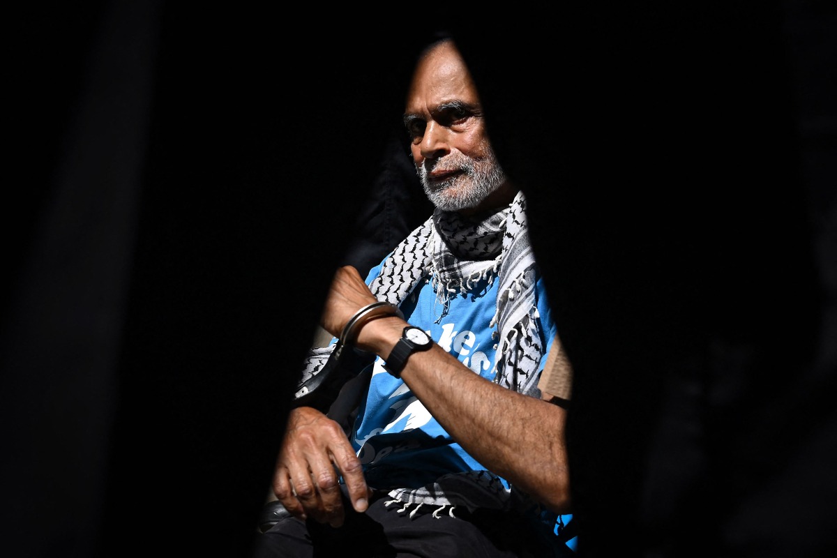 A Protester is pictured in handcuffs through a police officers legs before being carried away after being arrested as people gather in support of the pro-palestinian group 