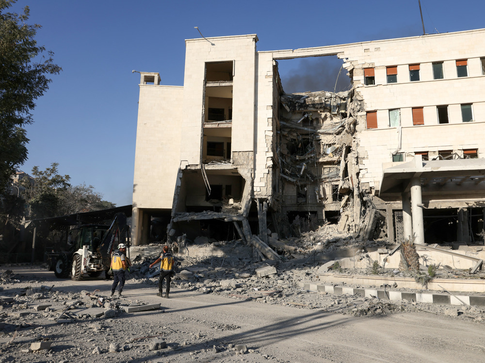 Rescuers walk inside the heavily damaged Syrian army and defence ministry headquarters complex in Damascus, following Israeli strikes on July 16, 2025. (Photo by Bakr ALkasem / AFP)