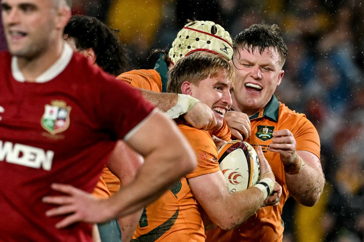 Australia's Tate McDermott (C) celebrates a try with teammates during the third rugby Test match between Australia and the British and Irish Lions at Stadium Australia in Sydney on August 2, 2025. (Photo by Saeed KHAN / AFP)
