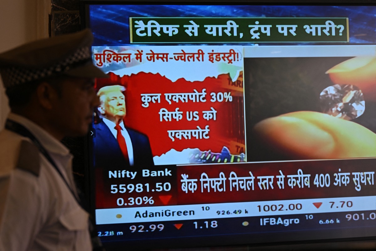 A broadcast screen of the Bombay Stock Exchange (BSE) is pictured in Mumbai on July 31, 2025, which shows the impact on the gems and jewellery sector while depicting news of US President Donald Trump unveiling sweeping new trade tariffs. (Photo by Indranil MUKHERJEE / AFP)