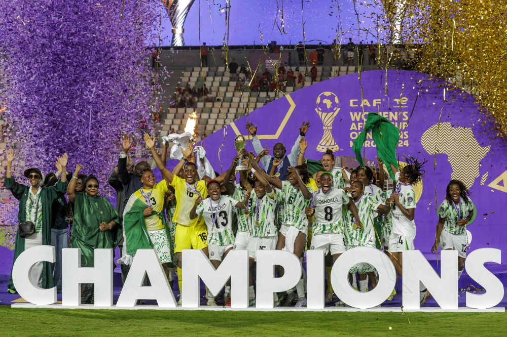 (Files) Nigeria's players celebrate with the trophy on the podium after winning the 2025 Women's Africa Cup of Nations final football match on July 26, 2025. (Photo by Abdel Majid Bziouat / AFP)