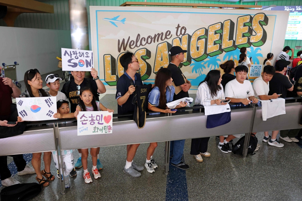 Supporters of South Korean football player Son Heung-min wait for his arrival at the Los Angeles International Airport in Los Angeles, California on August 5, 2025. (Photo by Patrick T. Fallon / AFP)