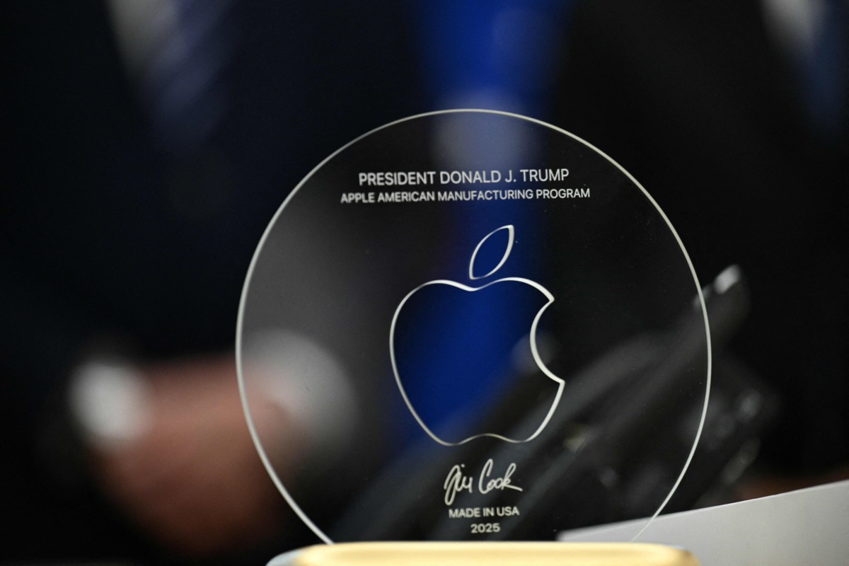 A memento presented by Apple CEO Tim Cook is seen on the Resolute Desk in the Oval Office of the White House in Washington, DC, on August 6, 2025 before announcing that Apple will invest an additional $100 billion in the United States, taking its total pledge to $600 billion over the next four years. (Photo by Brendan SMIALOWSKI / AFP)