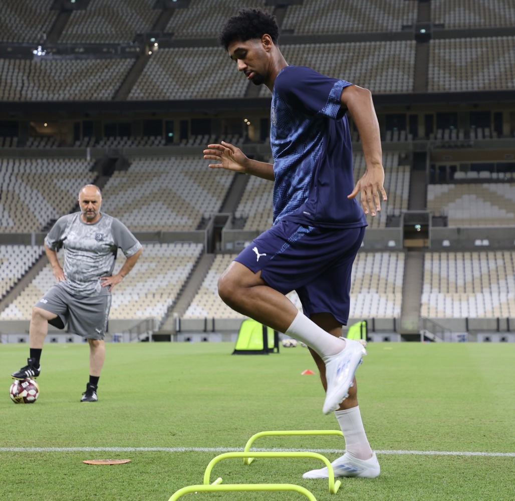 Al Duhail’s Homam Ahmed trains under the watchful eye of coach Djamel Belmadi during a session at Lusail Stadium.