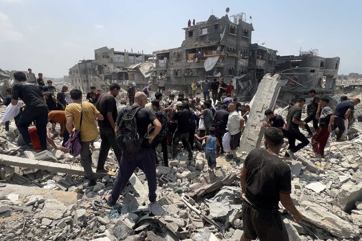 Palestinians hustle around a humanitarian parcel dropped by a military aircraft in Jabalia in the northern Gaza Strip on August 9, 2025. Photo by Bashar TALEB / AFP