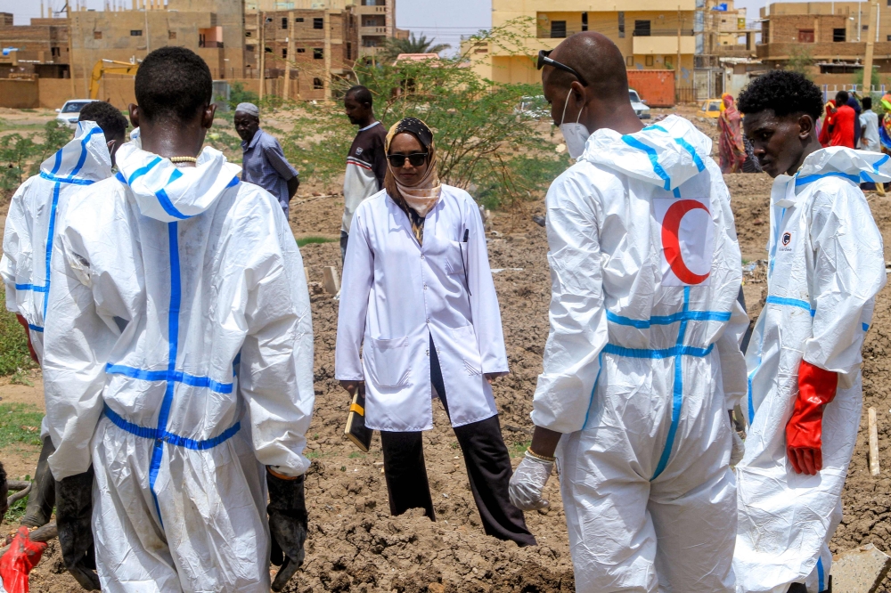 Members of the Sudanese Red Crescent and forensic experts exhume the remains of people from makeshift graves for reburial in the local cemetery in Khartoum's southern suburb of al-Azhari on August 2, 2025 after the dead were buried in a rush when the area was under control of the Rapid Support Forces (RSF) paramilitaries. (Photo by Ebrahim Hamid / AFP)
