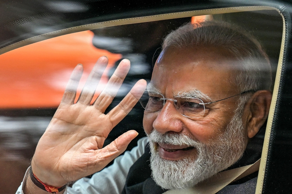 India's Prime Minister Narendra Modi waves upon his arrival to inaugurate the new Vande Bharat passenger train and Yellow Line of the Namma Metro in Bengaluru on August 10, 2025. (Photo by Idrees Mohammed / AFP)