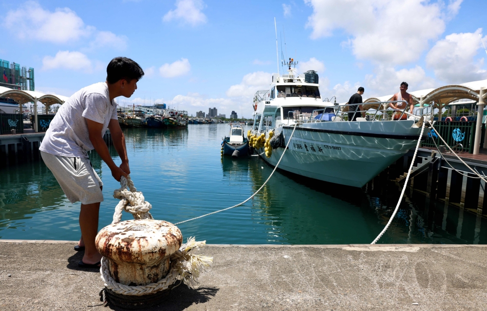 Fishermen secure their boats at Wushih Harbor in Yilan as Typhoon Podul approaches on August 12, 2025 (Photo by I-Hwa Cheng / AFP)