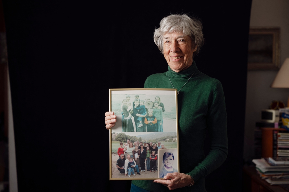 Survivor of Japanese camps during World War II and psychologist Tineke Einthoven, 87, poses with family photographs at her home in Monaco, on January 13, 2025. (Photo by Frederic Dides / AFP)
