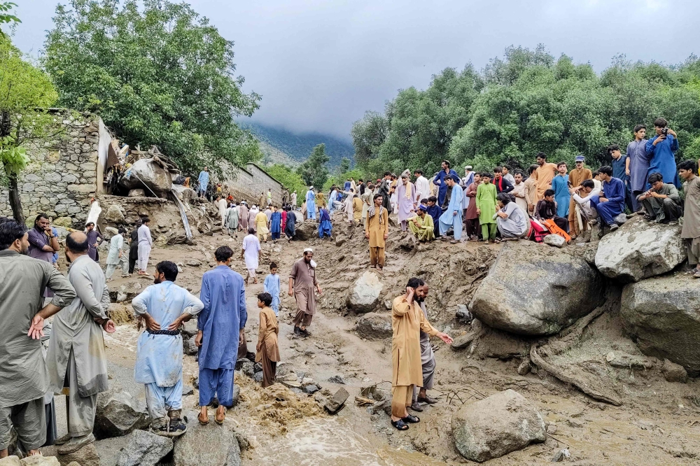 People gathered at the site of a flashflood in Salarzai Tehsil of Pakistan's Bajaur district on August 15, 2025. (Photo by AFP)