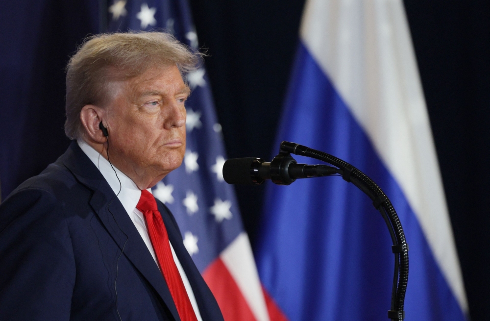 In this pool photograph distributed by the Russian state agency Sputnik, US President Donald Trump listens to Russian President Vladimir Putin during a joint press conference after participating in a US-Russia summit on Ukraine at Joint Base Elmendorf-Richardson in Anchorage, Alaska, on August 15, 2025. (Photo by Gavriil GRIGOROV / POOL / AFP)