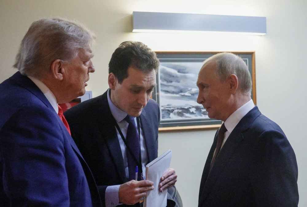 In this pool photograph distributed by the Russian state agency Sputnik, US President Donald Trump (L) and Russian President Vladimir Putin (R) chat before holding a joint press conference following a US-Russia summit on Ukraine at Joint Base Elmendorf-Richardson in Anchorage, Alaska, on August 15, 2025. (Photo by Gavriil Grigorov / POOL / AFP)