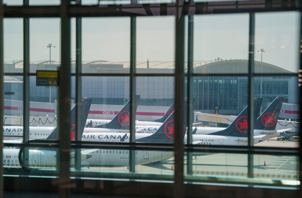 Air Canada airplanes stand on the tarmac at Pearson International Airport in Toronto on August 16, 2025. (Photo by Peter Power / AFP)