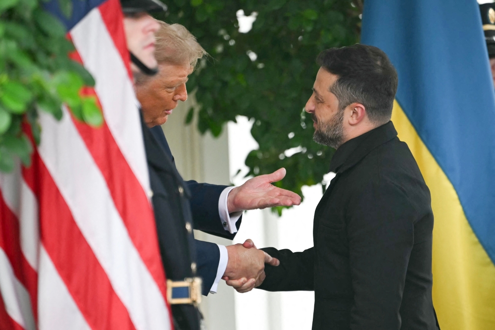 Ukrainian President Volodymyr Zelensky is greeted by US President Donald Trump (left) upon arrival at the White House West Wing in Washington, DC, on August 18, 2025. (Photo by Andrew Caballero-Reynolds / AFP)