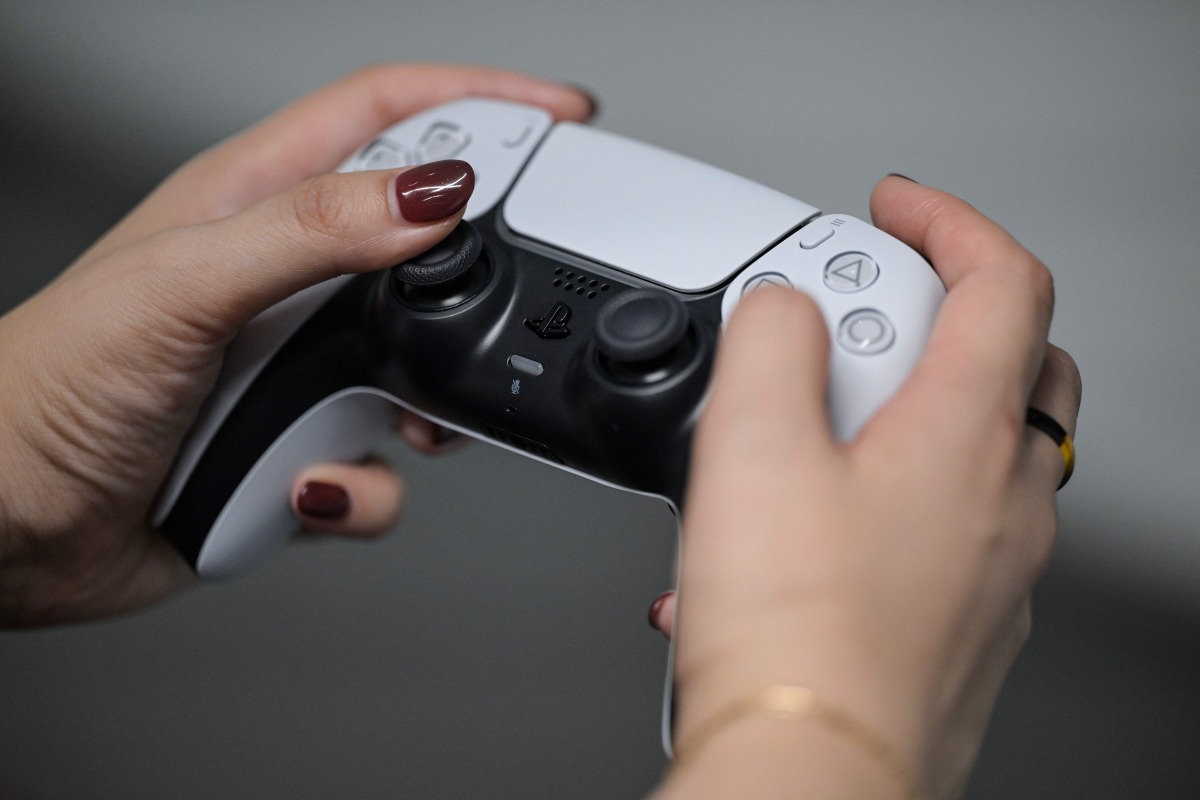 File: A PlayStation employee demonstrates how to use the PlayStation 5 Pro console, at the Sony headquarters building in central Tokyo on November 27, 2024. (Photo by Richard A Brooks / AFP)