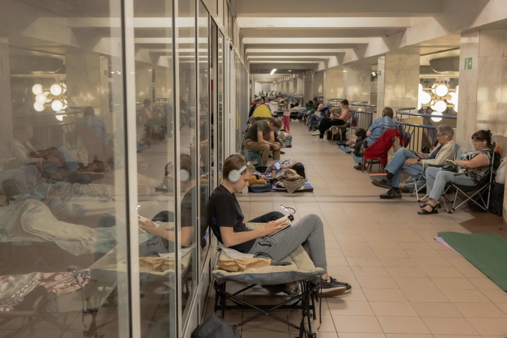 People take shelter at a metro station during Russian air attacks in Kyiv on August 21, 2025, amid the Russian invasion of Ukraine. (Photo by Roman Pilipey / AFP)