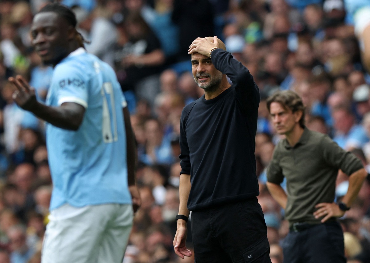 Manchester City's Spanish manager Pep Guardiola (C) and Tottenham Hotspur's Danish head coach Thomas Frank (R) react during the English Premier League football match between Manchester City and Tottenham Hotspur at the Etihad Stadium in Manchester, north west England, on August 23, 2025. (Photo by Darren Staples / AFP) /