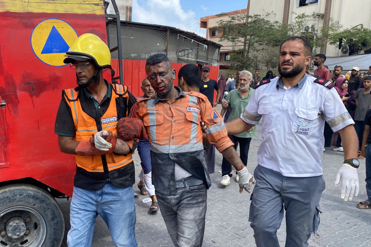 Graphic content / Palestinian medics bring an injured civil defence member at Nasser Hospital in Khan Yunis, in the southern Gaza Strip, on August 25, 2025, following Israeli air strikes.  Israeli strikes on the hospital killed at least 15 people on August 25, including four journalists and one civil defence member. (Photo by AFP)