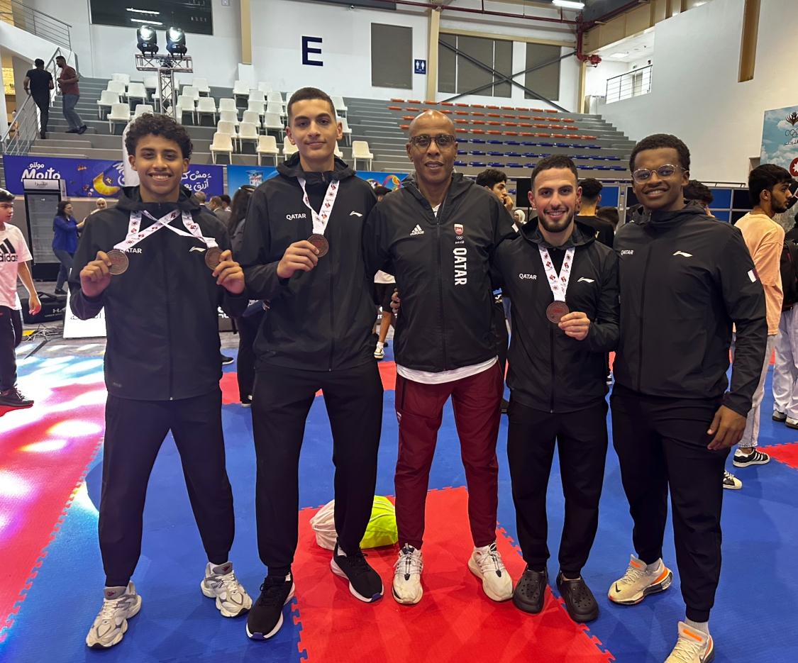 Qatari athletes pose with their medals.