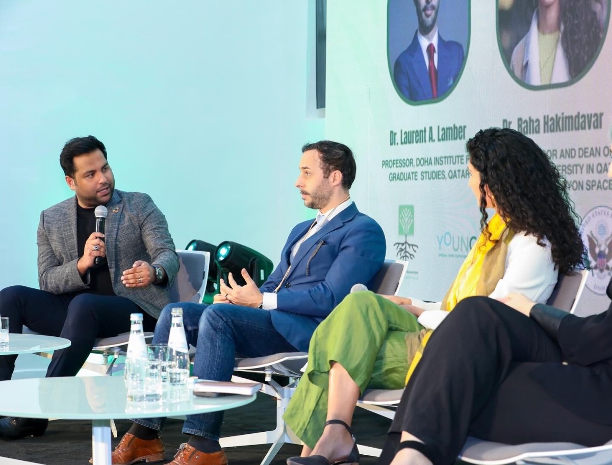 Neeshad Shafi, co-founder and executive director of Arab Youth Climate Movement Qatar, speaking with panel speakers during a climate-related event. 