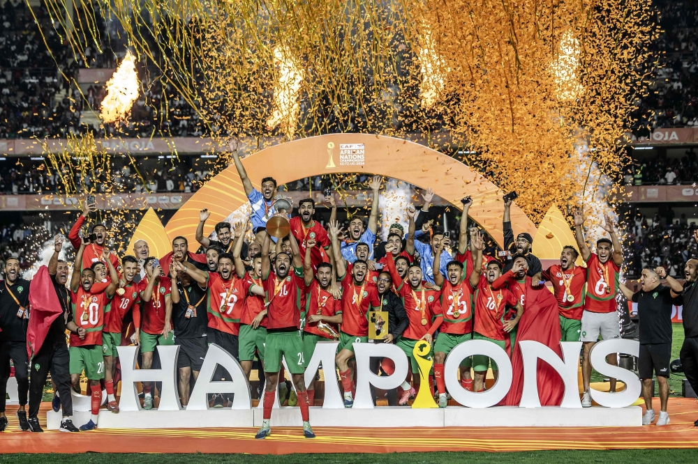 Morocco's defender #24 Mohamed Rabie Hrimat holds the trophy as Morocco celebrates winning the African Nations Championship (CHAN) final against Madagascar at Kasarani Stadium in Nairobi, on August 30, 2025. (Photo by Luis Tato / AFP)