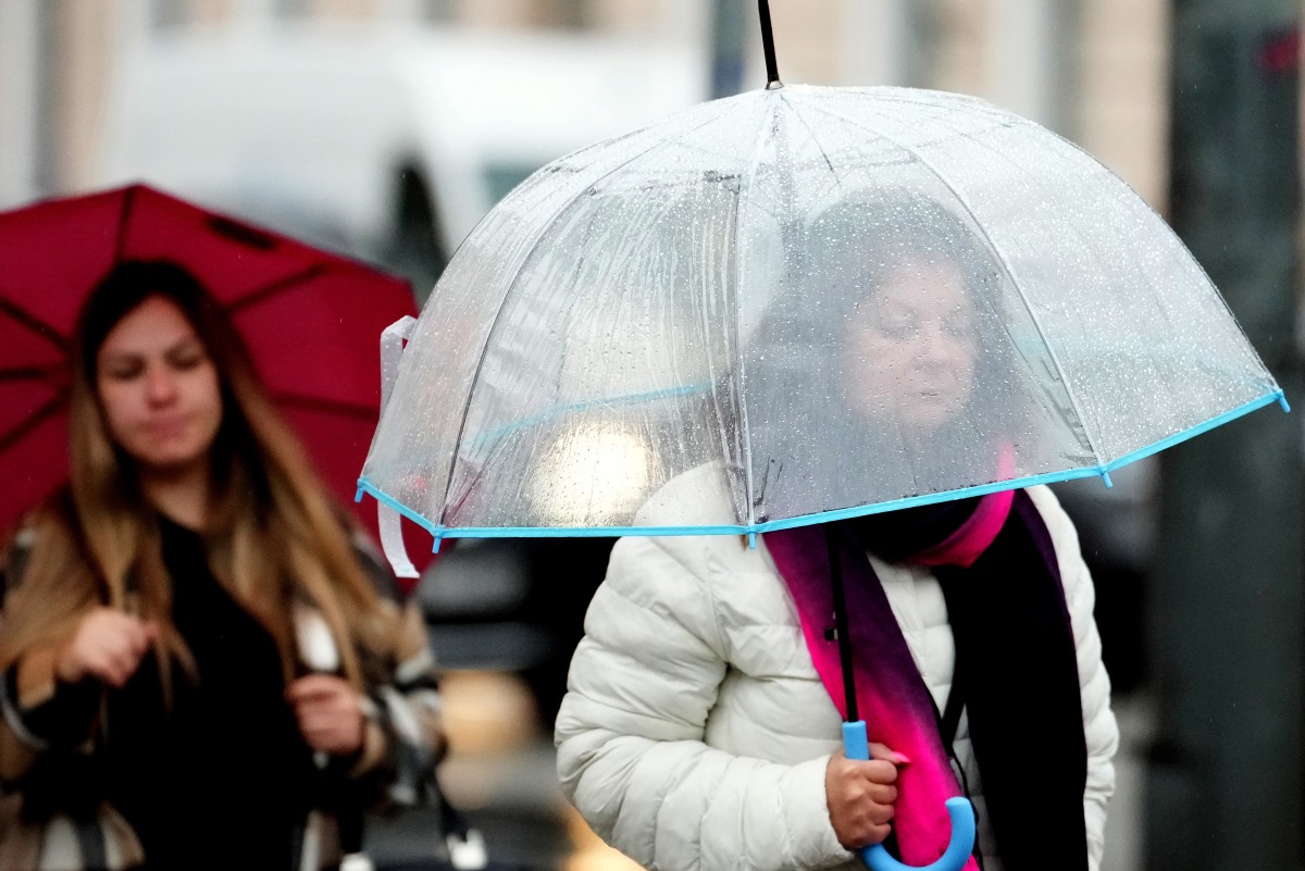 People walk against rainfall in Riga, Latvia, Aug. 26, 2025. (Photo by Edijs Palens/Xinhua)
