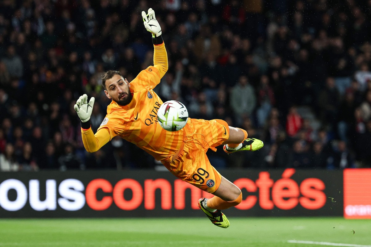 (FILES) Paris Saint-Germain's Italian goalkeeper #99 Gianluigi Donnarumma makes a save during the French L1 football match between Paris Saint-Germain (PSG) and Olympique Lyonnais (Lyon) at the Parc des Princes stadium in Paris on April 21, 2024. (Photo by Franck FIFE / AFP)
