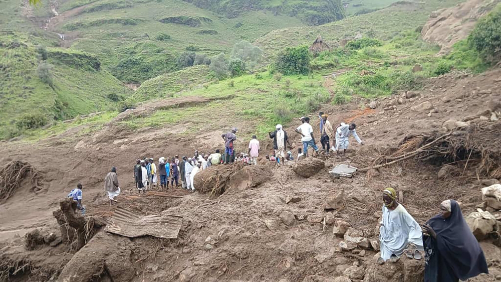 This handout image made available by the Sudan Liberation Movement/Army (SLM), on September 2, 2025, shows people inspecting the debris after a landslide devastated the village of Tarasin in Sudan's Jebel Marra area. (Photo by Sudan Liberation Movement /Army / AFP)