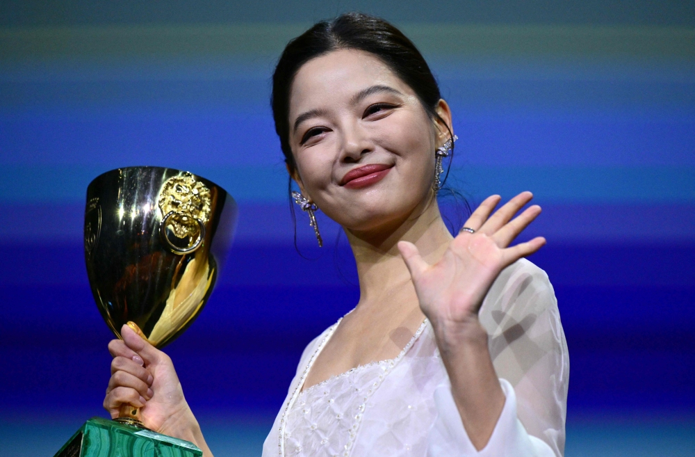 Chinese actress Xin Zhilei poses with the Coppa Volpi for Best Actress she received for her part in 